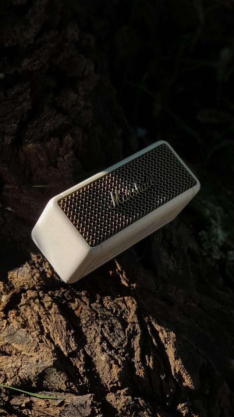 Portable Bluetooth speaker resting on tree bark outdoors